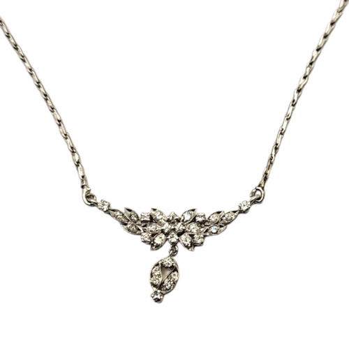 108 - A VINTAGE WHITE METAL AND DIAMOND NECKLACE 
Having an arrangement of round cut stones forming a flor... 