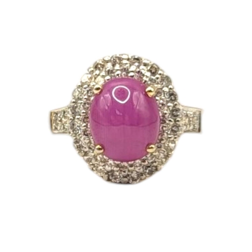 133 - A YELLOW METAL, DIAMOND 'STAR' RUBY AND DIAMOND CLUSTER RING
The cabochon cut stone edged with gradu... 