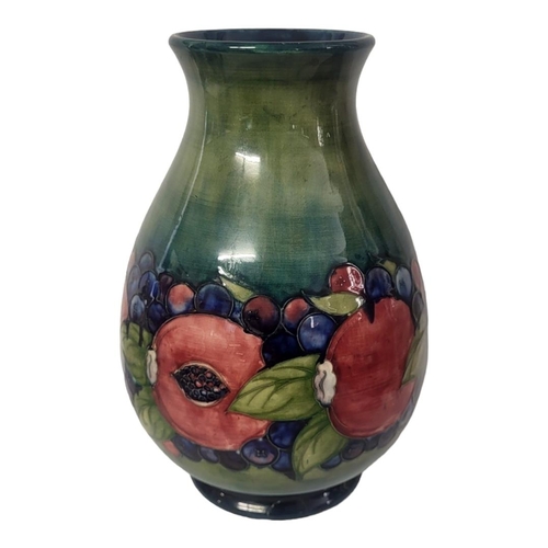 442 - A WILLIAM MOORCROFT POTTERY BALUSTER VASE, CIRCA 1930
In pomegranate, berry and leaf pattern, the bo... 