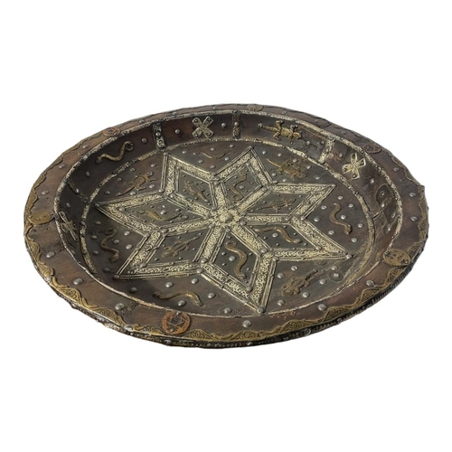 299 - AN ANTIQUE INDO-PERSIAN WOODEN TRIBAL SHALLOW BOWL
Centrally embossed with a white metal Arabesque s... 