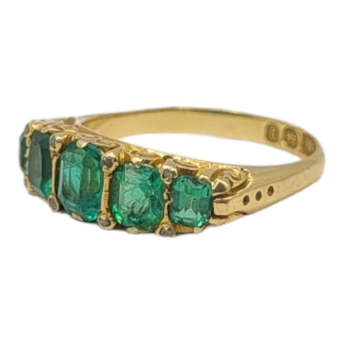 40 - AN EARLY 20TH CENTURY 18CT GOLD AND PASTE SET FIVE STONE RING
Having a row of emerald cut stones in ... 