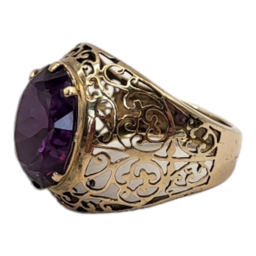 63 - A VINTAGE YELLOW METAL AND AMETHYST GENTS SIGNET RING
Oval faceted cut stone in a wide pierced scrol... 