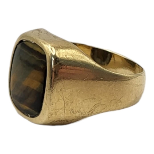 64 - A VINTAGE 9CT GOLD AND TIGER'S EYE GENTS SIGNET RING
The rectangular cut stone in plain 9ct gold mou... 