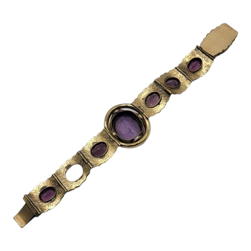 93 - A VICTORIAN GILT METAL AND AMETHYST GLASS BRACELET
Set with oval faceted stones in engraved decorati... 