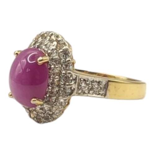 133 - A YELLOW METAL, DIAMOND 'STAR' RUBY AND DIAMOND CLUSTER RING
The cabochon cut stone edged with gradu... 