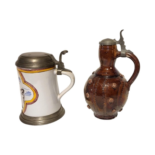 215 - A 19TH CENTURY GERMAN POTTERY AND PEWTER FLAGON
Having a single handle and incised and applied decor... 