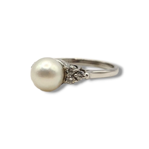 22 - AN 18CT WHITE GOLD, DIAMOND AND CULTURED PEARL RING
The single cultured pearl flanked by round cut d... 