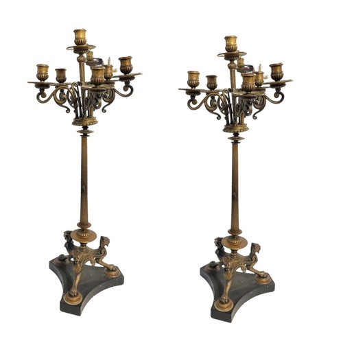 416 - A PAIR OF REGENCY STYLE EARLY 20TH CENTURY BRONZE SIX BRANCH CANDELABRA
The scrollwork arms below dr... 