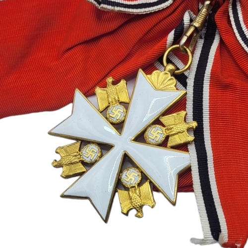 565 - A WWII GERMAN EAGLE STAR  BREAST BADGE AND  MEDAL
White metal with enamel on red, black and white sa... 