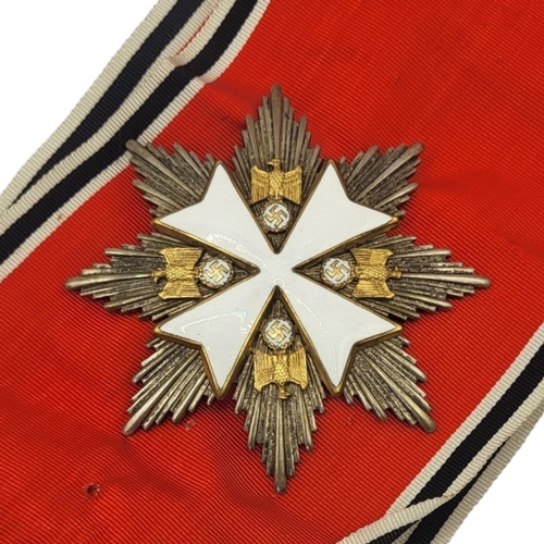 565 - A WWII GERMAN EAGLE STAR  BREAST BADGE AND  MEDAL
White metal with enamel on red, black and white sa... 