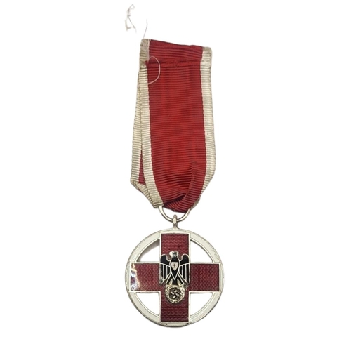 575 - A WWII GERMAN RED CROSS DECORATION MEDAL
Black enamel eagle on red and white enamel ground, on red a... 