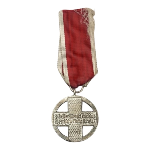 575 - A WWII GERMAN RED CROSS DECORATION MEDAL
Black enamel eagle on red and white enamel ground, on red a... 