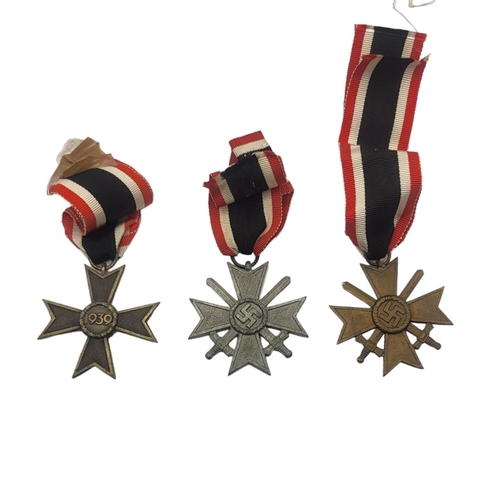 580 - A COLLECTION OF THREE WWII GERMAN WAR MERIT CROSS MEDALS
Two with swords, marked 1936.