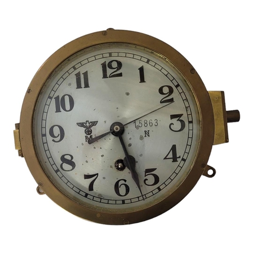 599 - A GERMAN WWII BRASS U-BOAT CLOCK
The silvered dial with spread eagle and engraved serial number 1586... 