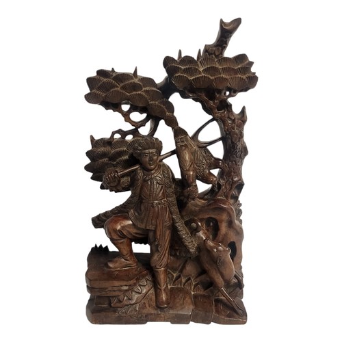 386 - AN EARLY 20TH CENTURY ORIENTAL STYLE HARDWOOD CARVING OF A FOREST HUNTER
Surrounded by animals and s... 