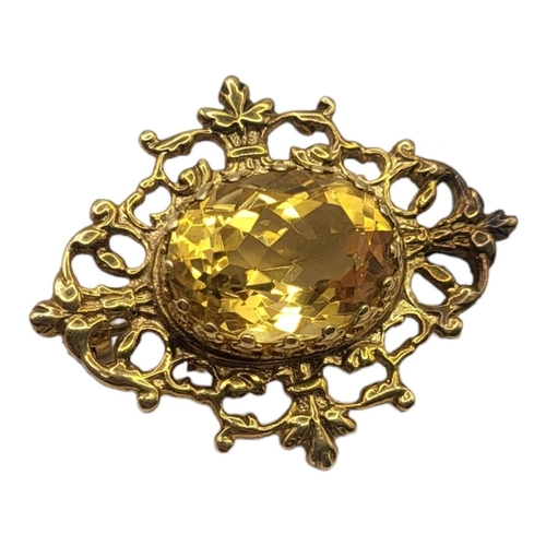 154 - A VINTAGE 9CT GOLD AND CITRINE BROOCH
The central oval faceted stone in a pierced design, in a fitte... 