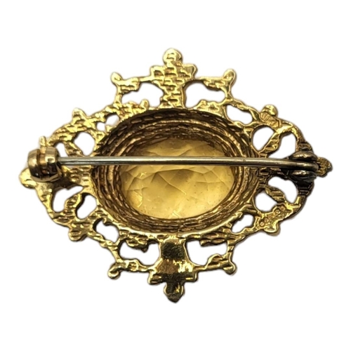 154 - A VINTAGE 9CT GOLD AND CITRINE BROOCH
The central oval faceted stone in a pierced design, in a fitte... 