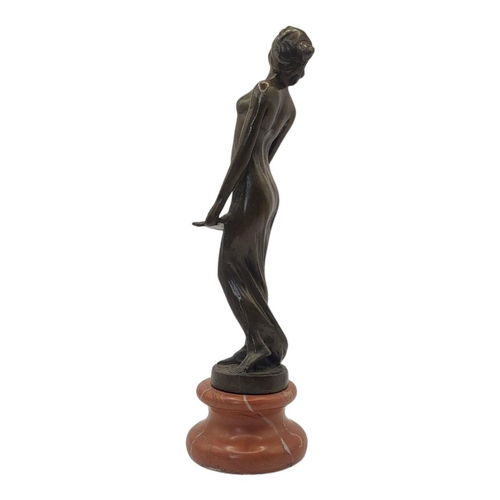 231 - AN ART DECO STYLE BRONZE FIGURE FORMED AS A NUDE LADY HOLDING A MUSIC SHEET 
On rouge marble pedesta... 