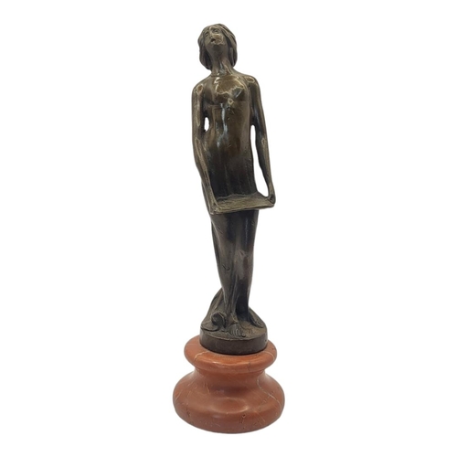 231 - AN ART DECO STYLE BRONZE FIGURE FORMED AS A NUDE LADY HOLDING A MUSIC SHEET 
On rouge marble pedesta... 