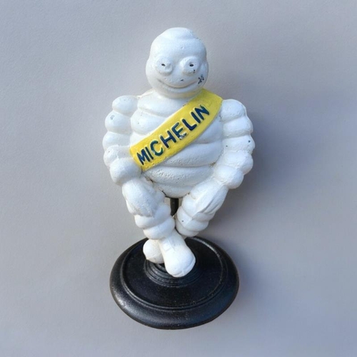 283 - A NOVELTY CAST IRON MICHELIN MAN FIGURE
With embossed logo and sash, sat on a rotating support with ... 