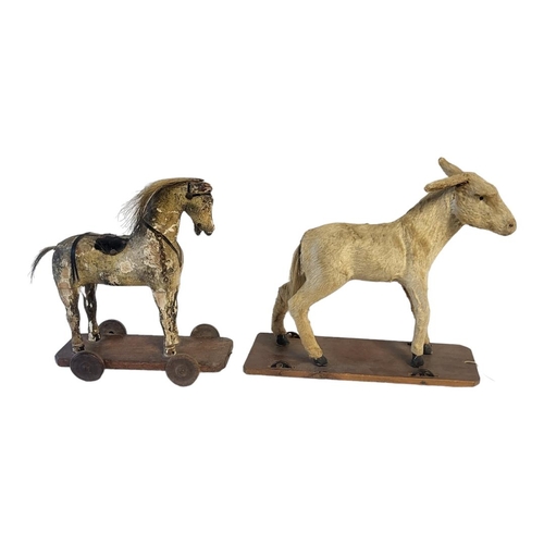 330 - AN EARLY VICTORIAN CHILD'S TOY HORSE
Carved pine and gesso painted body on wheels, with horsehair ma... 