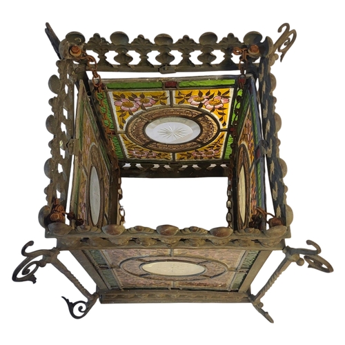 341 - A VICTORIAN AESTHETIC MOVEMENT STAINED GLASS AND METAL LANTERN
Four coloured glass panels within a g... 