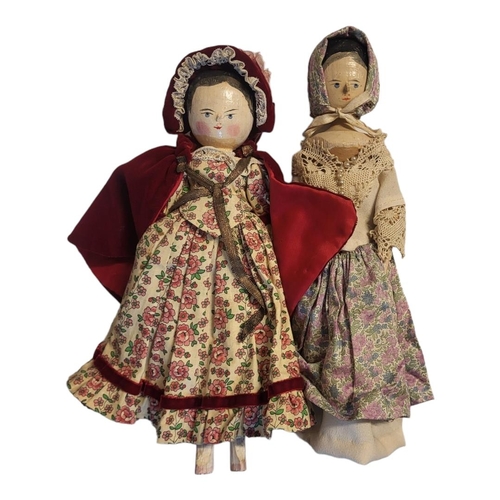 345 - TWO EARLY 20TH CENTURY DUTCH WOODEN DOLLS 
Naive painted faces, provincial dress, Continental wax pu... 