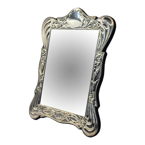 61 - A 20TH CENTURY SILVER EASEL MIRROR
Having embossed scrolled frame, hallmarked Birmingham, 1988, in o... 