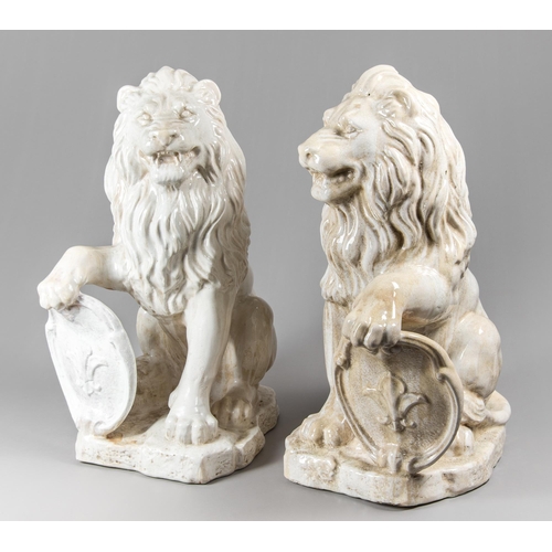 23 - A LARGE 20TH CENTURY PAIR OF GLAZED LIONS, BEARING FLEUR-DE-LIS EMBLEM SHIELDS.
(h 78cm x w 44cm x d... 