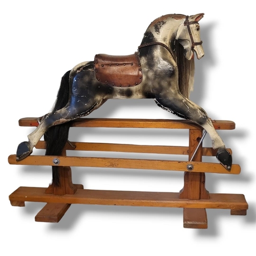 462A - AN EARLY 20TH CENTURY CHILD’S DAPPLE GREY WOODEN ROCKING HORSE
With real hair mane and tan leather t... 