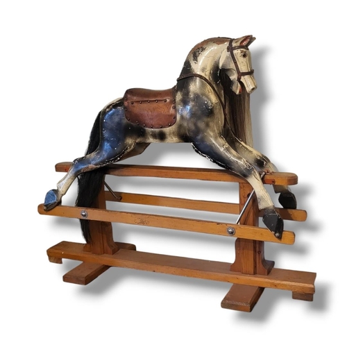 462A - AN EARLY 20TH CENTURY CHILD’S DAPPLE GREY WOODEN ROCKING HORSE
With real hair mane and tan leather t... 