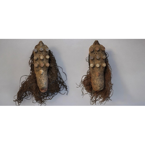 402 - A PAIR OF AFRICAN CARVED WOODEN GREBO MASKS
Having nine protruding mounts and old painted decoration... 