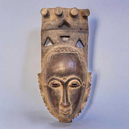 403 - AN AFRICAN TRIBAL CARVED WOODEN BAULE PORTRAIT MASK
Having four producing legs to finial and pierced... 