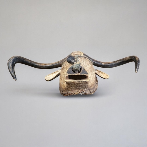 406 - AN AFRICAN CARVED WOODEN TABWA BULL MASK
Protruding horns and ears, painted decoration and bell to n... 