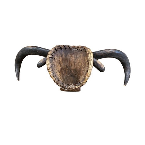 406 - AN AFRICAN CARVED WOODEN TABWA BULL MASK
Protruding horns and ears, painted decoration and bell to n... 