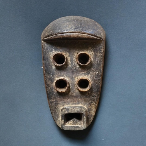 410 - AN AFRICAN TRIBAL CARVED WOODEN  GREBO 'KRU' MASK
Four eye holes, square mouth.
(approx 33cm)

Condi... 