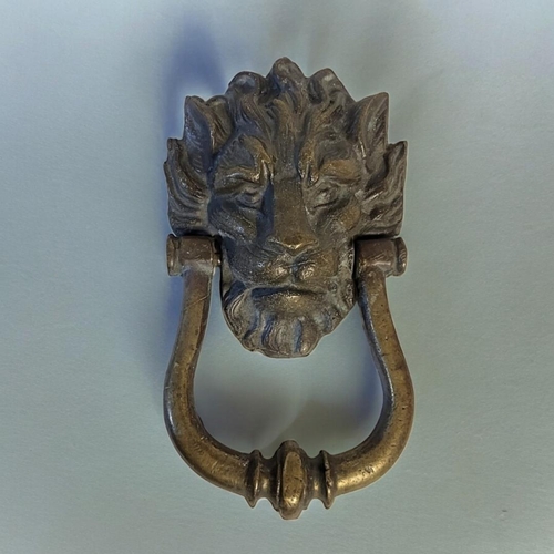 437 - AN EARLY 20TH CENTURY BRASS LION MASK KNOCKER
Having a tapering knocker.
(approx 12cm x 23cm)

Condi... 