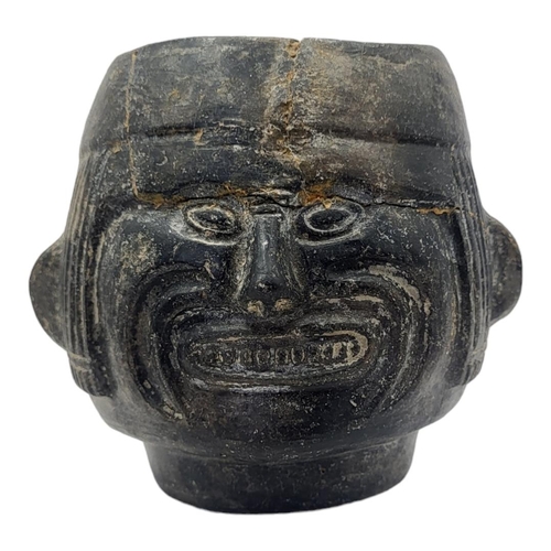 446 - A SOUTH AMERICAN POTTERY FIGURAL VESSEL
Having a grimacing face to body and reeds to headdress.
(app... 