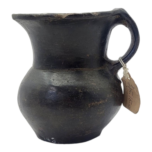 447 - A SOUTH AMERICAN BLACKWARE POTTERY JUG
Having a single handle and inlaid metallic mounts to rim.
(ap... 