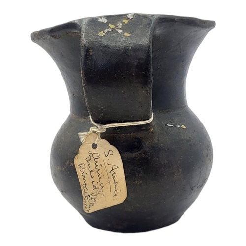 447 - A SOUTH AMERICAN BLACKWARE POTTERY JUG
Having a single handle and inlaid metallic mounts to rim.
(ap... 