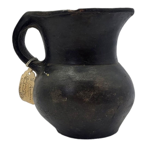 447 - A SOUTH AMERICAN BLACKWARE POTTERY JUG
Having a single handle and inlaid metallic mounts to rim.
(ap... 