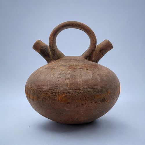 459 - A SOUTH AMERICAN TERRACOTTA POTTERY DOUBLE SPOUT VASE
Single handle with two spouts and incised deco... 