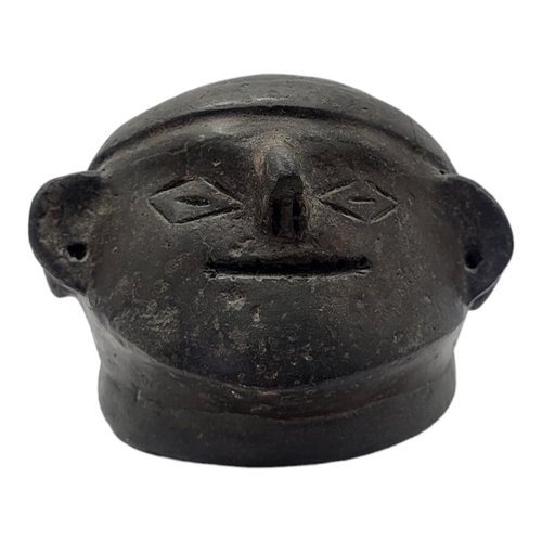 472 - A SOUTH AMERICAN BLACKWARE POTTERY MASK BOWL
Having pierced holes to ears and  incised facial featur... 