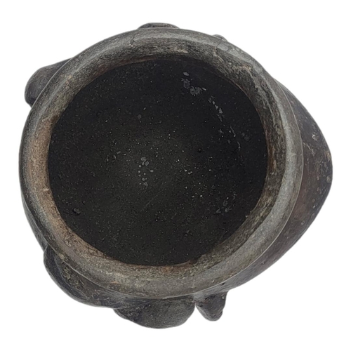 472 - A SOUTH AMERICAN BLACKWARE POTTERY MASK BOWL
Having pierced holes to ears and  incised facial featur... 