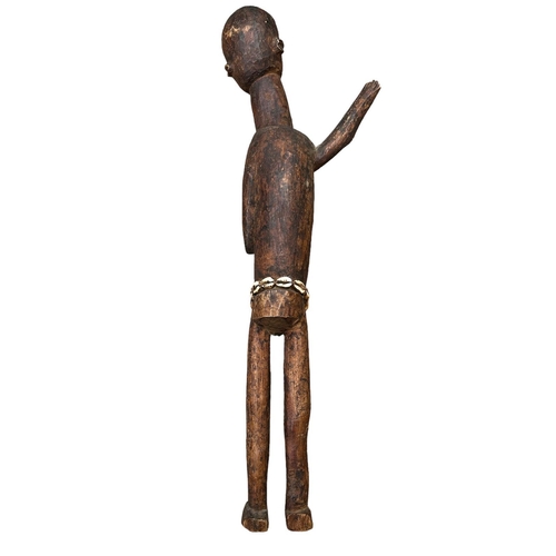 483 - AN AFRICAN LOBI/GHANA CARVED WOODEN FIGURE
Elongated female form with one arm raised and shells to w... 