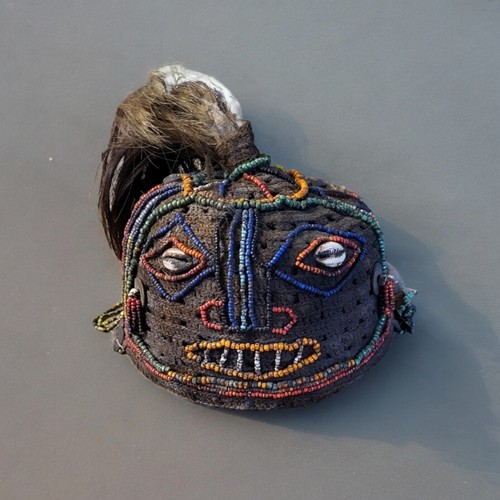 432 - A VINTAGE TRIBAL AFRICAN BEADWORK AND SHELL MASK HEADDRESS
Having animal hair finial, coloured glass... 