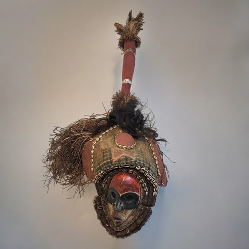 401 - AN AFRICAN TRIBAL CARVED WOODEN  DAN MASK/HEADDRESS
Having feathers to finial, carved wooden red and... 