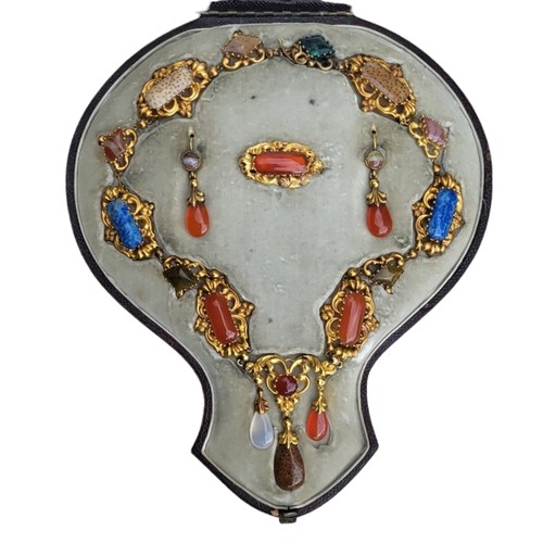 101 - A 19TH CENTURY YELLOW METAL, CARNELIAN AND SPECIMEN HARDSTONE JEWELLERY SUITE
Comprising a necklace ... 