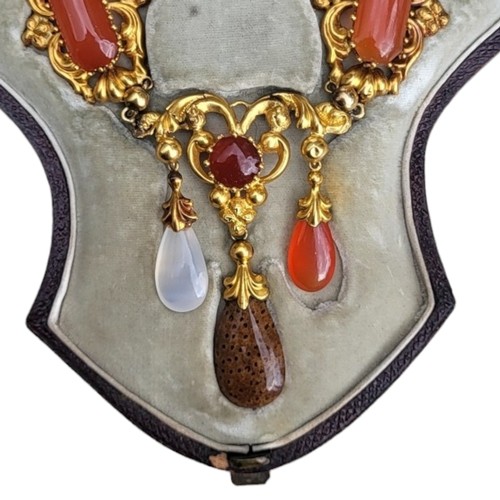 101 - A 19TH CENTURY YELLOW METAL, CARNELIAN AND SPECIMEN HARDSTONE JEWELLERY SUITE
Comprising a necklace ... 