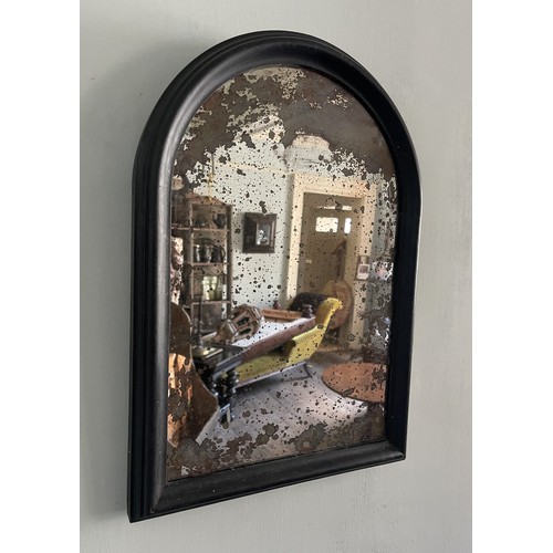 28 - A 19TH CENTURY ARCHED WALL MIRROR WITH HEAVILY FOXED ORIGINAL MERCURY PLATE IN AN EBONISED FRAME. (h... 